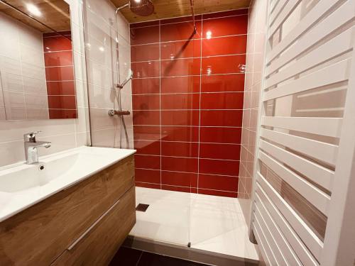 La salle de bains est pourvue d'un lavabo et d'une douche avec du carrelage rouge. dans l'établissement Vallandry: Apt 2 pièces 34m², 4 pers, proche pistes et centre, casier à skis - FR-1-757-118, à Landry