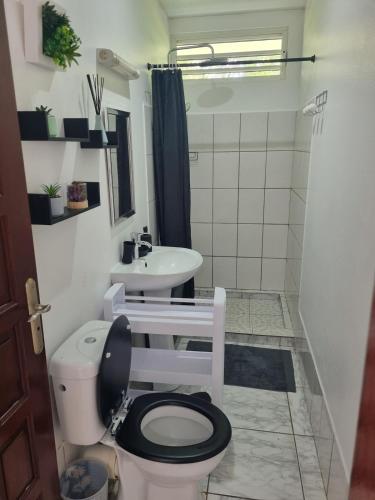 a bathroom with a toilet and a sink at Résidence in Matoury
