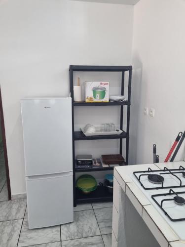 a kitchen with a white refrigerator and a stove at Résidence in Matoury