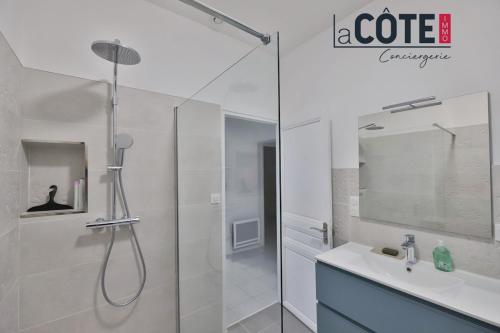 une salle de bain blanche avec une douche et un lavabo dans l'établissement L'Oursinade, à Carry-le-Rouet