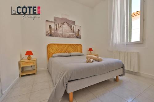 une chambre avec un lit avec un tableau sur le mur dans l'établissement L'Oursinade, à Carry-le-Rouet