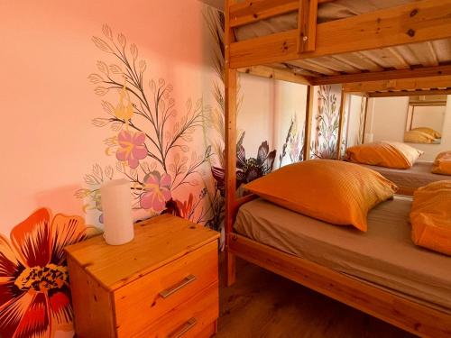 a bedroom with two bunk beds with a flower wallpaper at Csomópont Családi Vendégház in Somogytúr