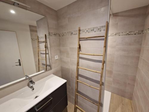 une salle de bain avec un lavabo et un miroir dans l'établissement Maison moderne pour 8 pers. à 600m de la plage avec grand jardin - FR-1-639-140, à Sarzeau