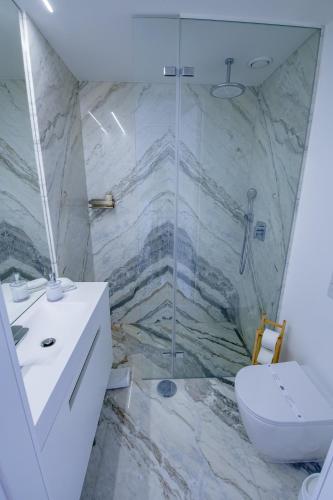 a bathroom with a shower and a toilet and a sink at Atlantis Ocean Front in Vila Nova de Gaia