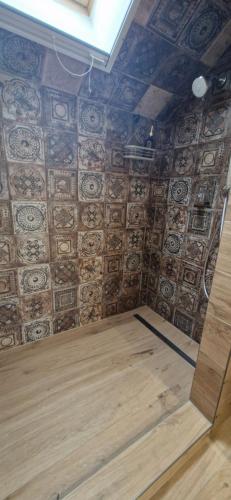 a room with a wooden floor and a wall with tiles at Kapitány MP Art Luxury Apartman in Balatonboglár