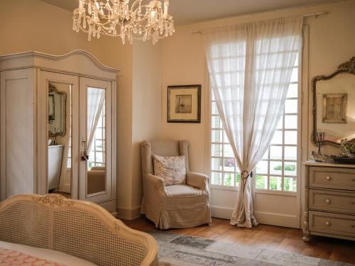 - une chambre avec une chaise et un lustre dans l'établissement Venez Chez Vous La Villa des Pensières, à Veyrier-du-Lac