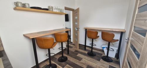 a room with two bar stools and a table at Kapitány MP Art Luxury Apartman in Balatonboglár