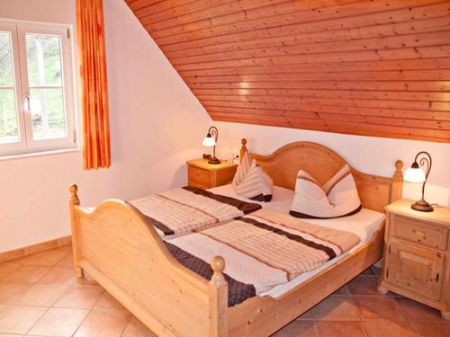 Schlafzimmer mit Holzbett und Holzdecke in der Unterkunft Vogtadeshof in Wolfach