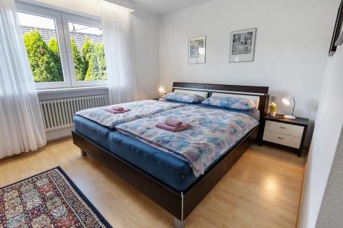 a bedroom with a bed with a blue comforter and a window at Ferienwohnung Millot in Gernsbach
