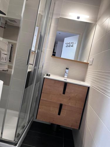 une salle de bain avec un lavabo et un miroir dans l'établissement Le Grillon, à Ax-les-Thermes