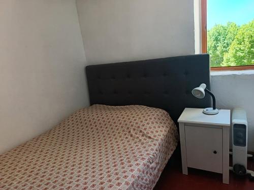 - une chambre avec un lit et une lampe sur une table de chevet dans l'établissement La montée des Pénitents, à Saint-Chamas