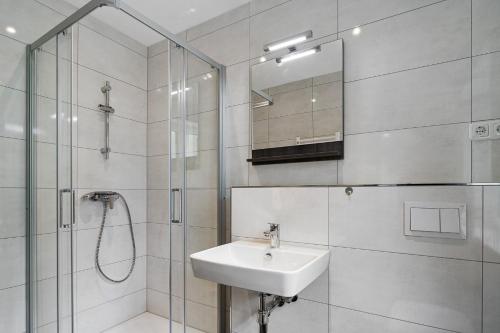 a white bathroom with a sink and a shower at Förde Hotel Kiel in Kiel