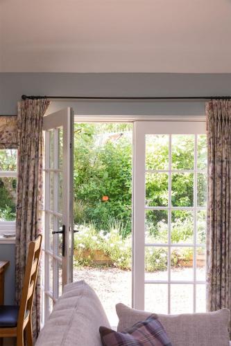 a living room with a sliding glass door at The Heritage Cottage in Swinton