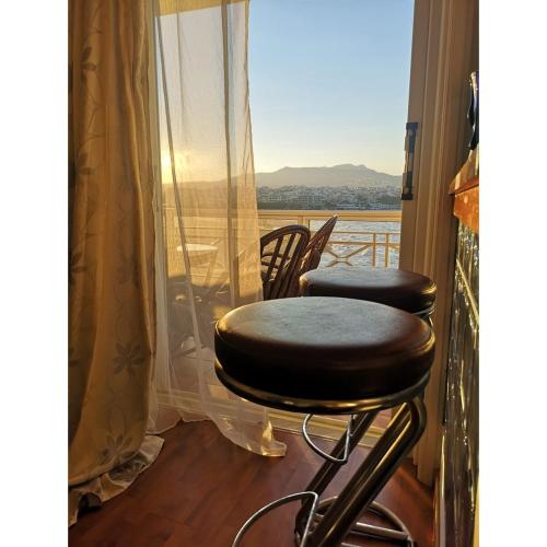 a balcony with two stools and a view of the ocean at Paradise found in Rafina