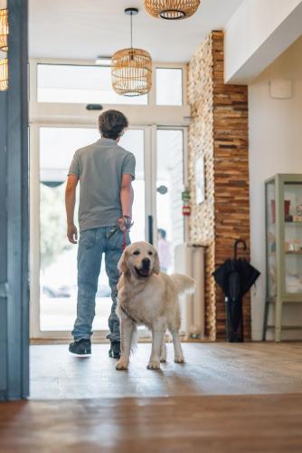 a man standing with a dog in front of a door at Beach Hotel - Le Grand Chalet in Ronce-les-Bains