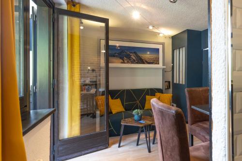 une pièce avec un miroir, une table et des chaises dans l'établissement Charmant Appartement avec balcon, à Chamonix-Mont-Blanc