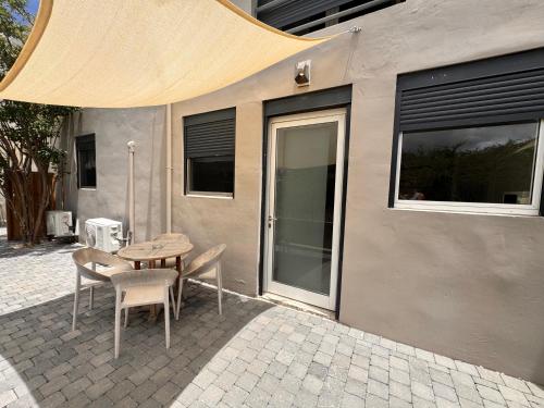a table and chairs in front of a building at Boutique Hotel & apartments JT Curaçao in Willemstad