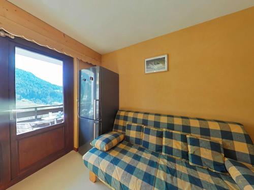 - une chambre avec un canapé et une grande fenêtre dans l'établissement Studio ensoleillé avec balcon Sud, parking, navette, 4 couchages - Le Grand-Bornand - FR-1-241-98, au Grand-Bornand