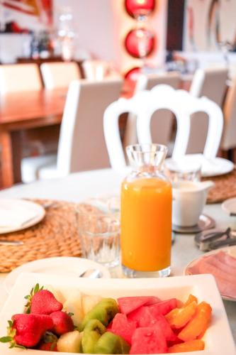 a plate of fruit and a glass of orange juice at Monte de São Francisco Country House in Vale de Maceira