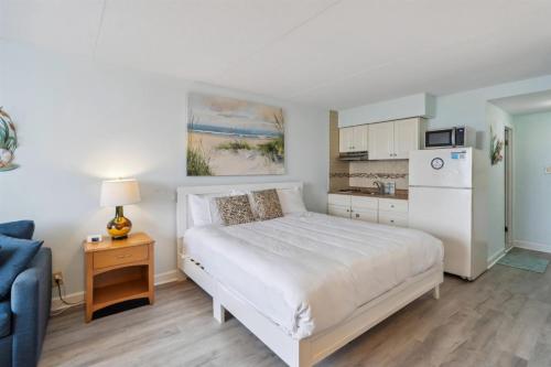 Un dormitorio con una cama blanca y una cocina. en 6201 Ocean Ave, Unit 214 - The Nassau Inn, en Wildwood