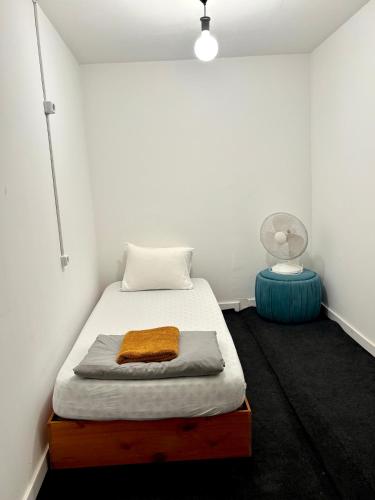 a bedroom with a bed with a pillow and a fan at Ndussole Guest House in Porto