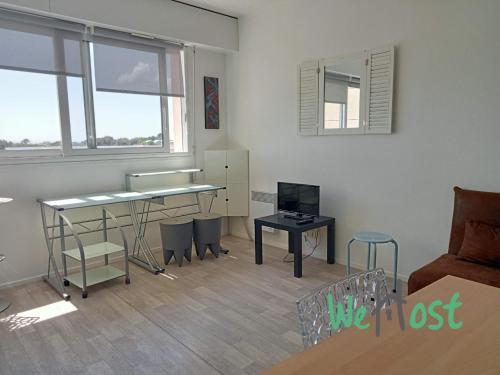 un salon avec un bureau et une table dans l'établissement Alfred - Studio - Seafront - Parking, à La Rochelle