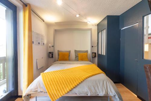 a bedroom with a bed with a yellow blanket on it at Charmant Appartement avec balcon in Chamonix-Mont-Blanc
