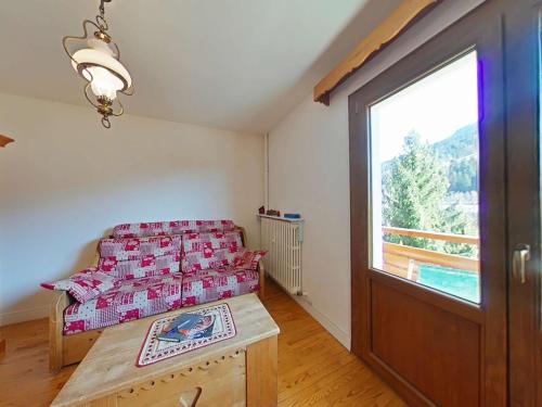 une chambre avec un lit et une grande fenêtre dans l'établissement Charmant 2 pièces, 6 couchages, centre du Grand-Bornand, parking, balcon sud - FR-1-241-136, au Grand-Bornand