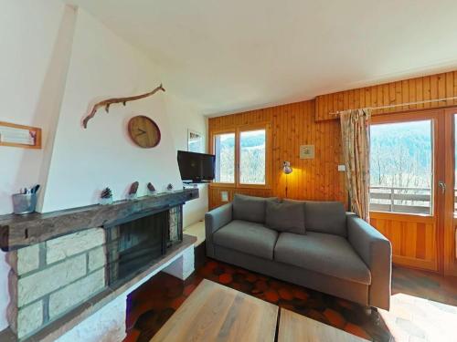 un salon avec un canapé et une cheminée dans l'établissement GRAND BORNAND, Appt 2 Pièces 5 Couchages, Calme, Cheminée, Navettes proches - FR-1-241-142, au Grand-Bornand