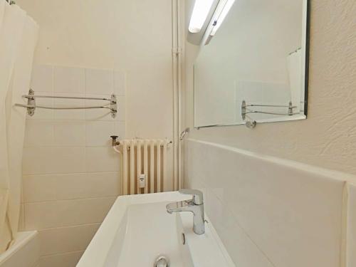 une salle de bain blanche avec un lavabo et un miroir dans l'établissement Charmant 2 pièces, 6 couchages, centre du Grand-Bornand, parking, balcon sud - FR-1-241-136, au Grand-Bornand