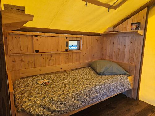 a bedroom with a bed in a wooden cabin at Quiétude & Nature in Le Boupère