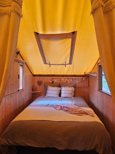 a bedroom with a large bed in a tent at Quiétude & Nature in Le Boupère