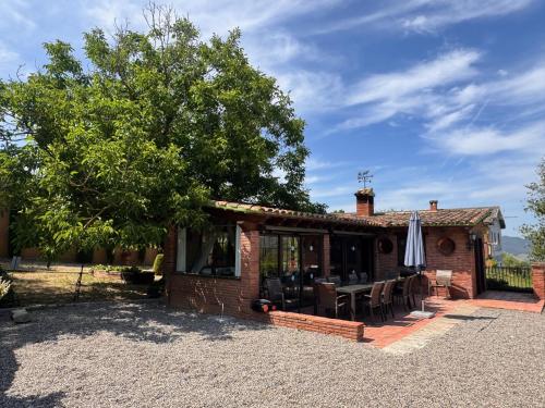 a brick house with a table and chairs at Finca La Pedrera in Capellades