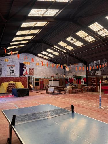 a ping pong table in a large room with a ping pong court at Finca La Pedrera in Capellades