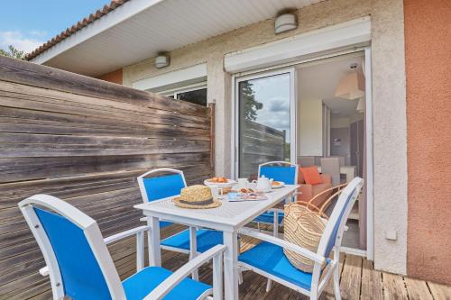 a table and chairs on the deck of a house at Résidence Odalys Côté Canal in Sallèles-dʼAude