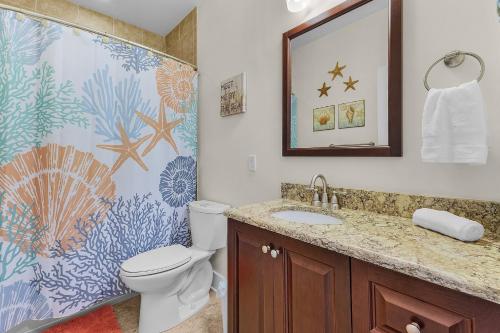 Un baño con inodoro, lavabo y espejo. en Close to Beach & Bay Retreat - Gulf Island Breeze - Roelens, en Fort Myers Beach