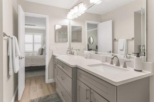 Un baño con dos lavabos y un espejo grande. en Isla del Sol Condos for Rent, en San Petersburgo