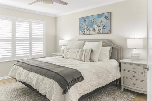 Habitación blanca con cama con mesita de noche y ventana en Isla del Sol Condos for Rent, en San Petersburgo