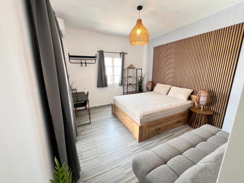 a bedroom with a bed and a couch at aeolian blu 2 in Parikia