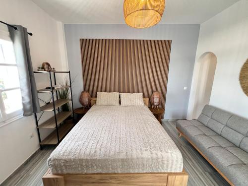 a bedroom with a bed and a couch at aeolian blu 2 in Parikia