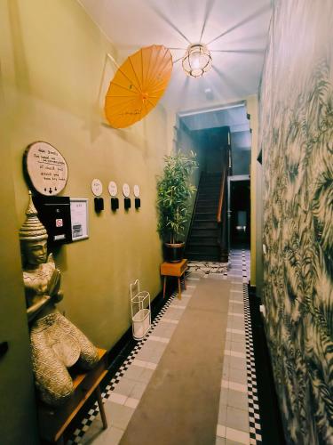 a hallway with a staircase with an umbrella and plants at 2Bangkok residence in Ghent