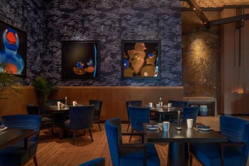 a dining room with tables and blue chairs at Banyan Tree Dubai at Bluewaters in Dubai