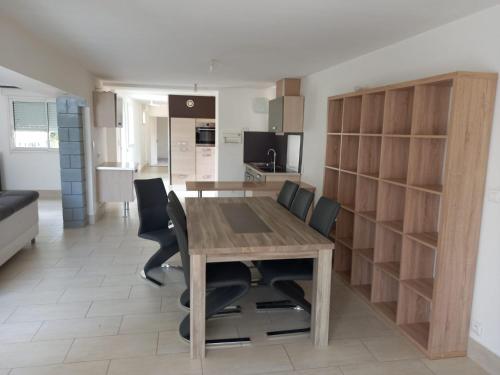une cuisine et une salle à manger avec une table et des chaises en bois dans l'établissement la plage, à Larmor-Plage
