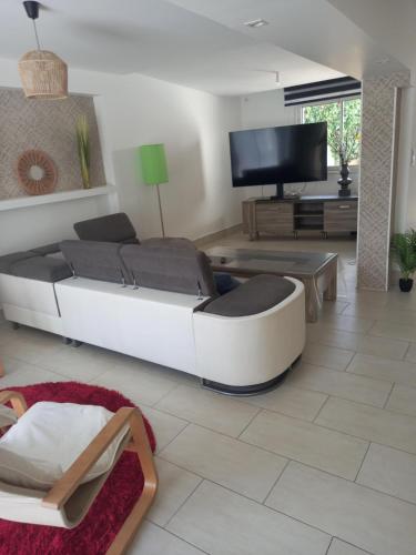 un salon avec un canapé et une télévision à écran plat dans l'établissement la plage, à Larmor-Plage
