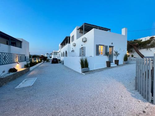 a white house with a fence in front of it at aeolian blu 10 in Parikia