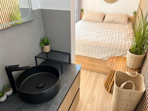 a bathroom with a black sink and a bed at aeolian blu 11 in Parikia