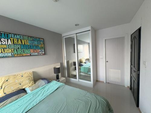 a bedroom with a bed and a painting on the wall at Acqua Condo By Dw in Ban Nong Chaeng