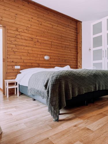 a bedroom with a large bed with a wooden wall at Das Luis in Altenmarkt im Pongau