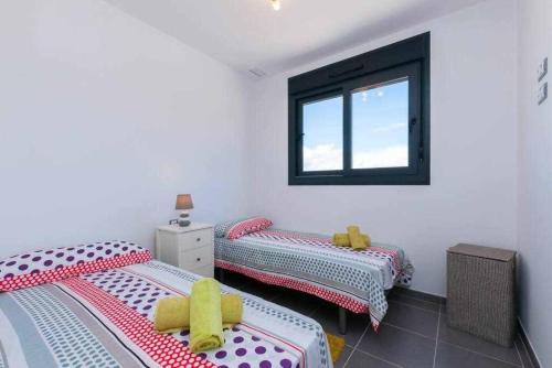 deux lits jumeaux dans une chambre avec fenêtre dans l'établissement Apartamento costero en una comunidad de lujo, à Arenales del Sol