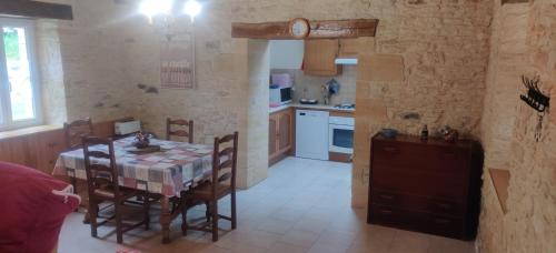 une cuisine avec une table et des chaises dans une pièce dans l'établissement Terre De Pierres - Gite Améthyste, à Saint-Geniès